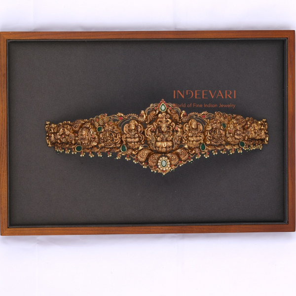 Ritvi Lakshmi Peacock Nakshi Vaddanam waist belt in 22K gold with Lakshmi and peacock motifs set with ruby, emerald and pearls