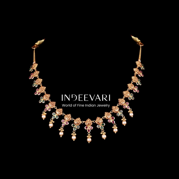 Refined Floral Heritage Pearl Necklace displaying series of intricate hand-carved floral motif links in antique gold, adorned with delicate ruby and green gemstone accents, cascading clusters of hanging lustrous pearls throughout, balanced symmetrical des