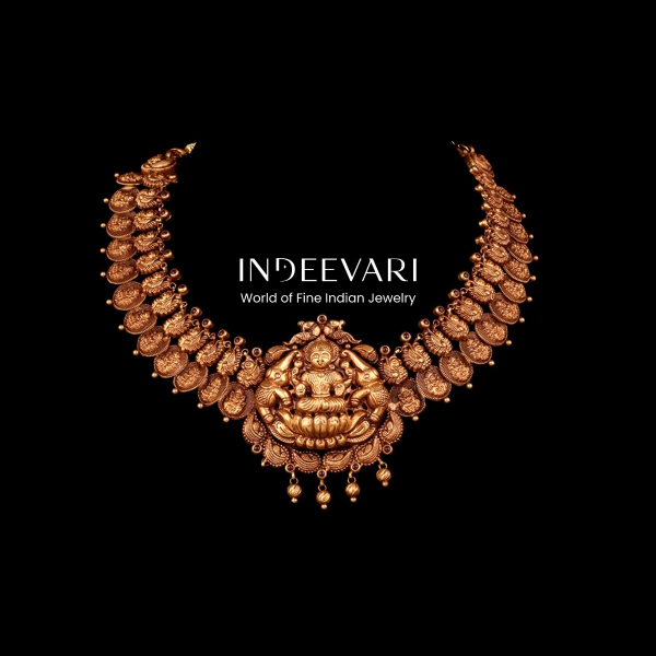 Treasured Antique Lakshmi Kasu Mala featuring grand hand-carved Lakshmi pendant centerpiece connected to traditional embossed gold coin chain (kasu), linked with intricate peacock and floral motif connectors, dangling ball accent embellishments throughout