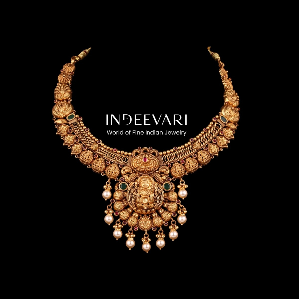 Opulent Lakshmi Nakshi Pearl Necklace displaying exquisite central Lakshmi pendant surrounded by ornate nakshi carved balls and intricate gold metalwork, clusters of antique beads with vibrant green and ruby gemstone accents, cascading luminous hanging pe