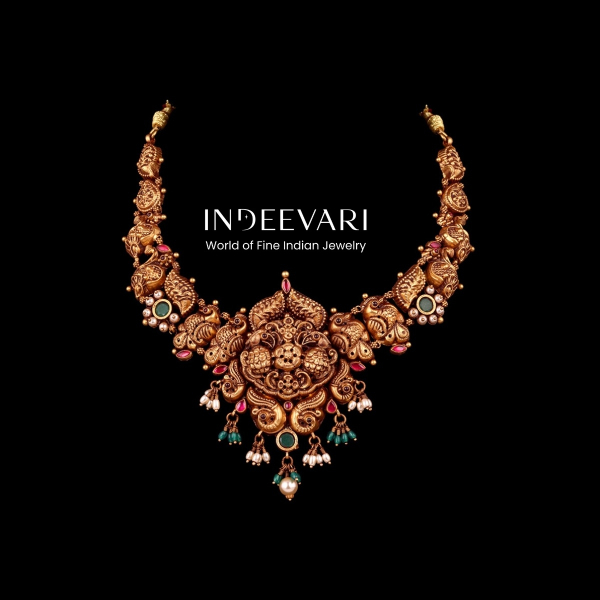 Exquisite Peacock Nakshi Emerald & Ruby Necklace displaying intricately carved peacock and floral motif arrangements throughout, magnificent central pendant with ornate nakshi carving, vibrant ruby and emerald gemstone accents, delicate pearl cluster deta