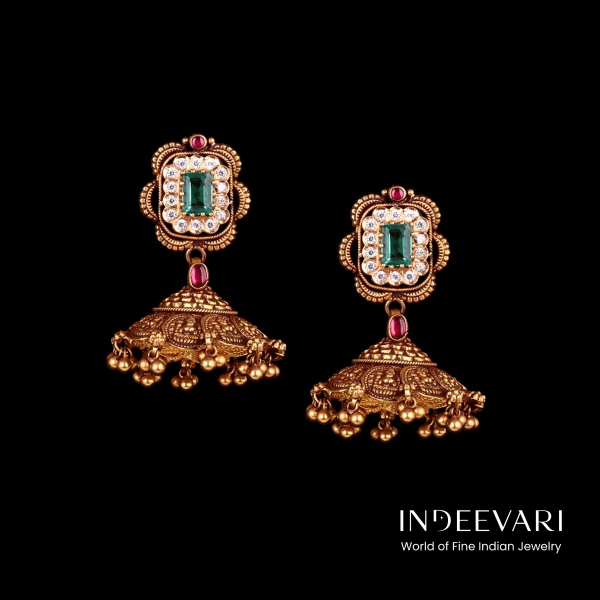 Elegant Emerald Nakshi Jhumki Earrings displaying square studs with striking emerald centers bordered by luminous kundan gemstone accents, ornate antique gold ornamental framing, ruby accents at top, suspended from ornate rounded jhumki pendants with deta