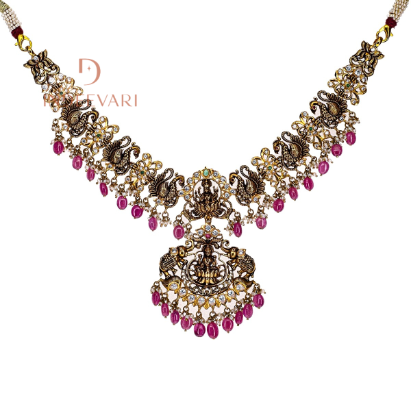 Ruhi Pachiwork necklace in 22K gold with peacock and Goddess Lakshmi motifs, embellished with rubies, emeralds, ruby beads, CZ stones, and pearls — traditional Indian gold necklace design