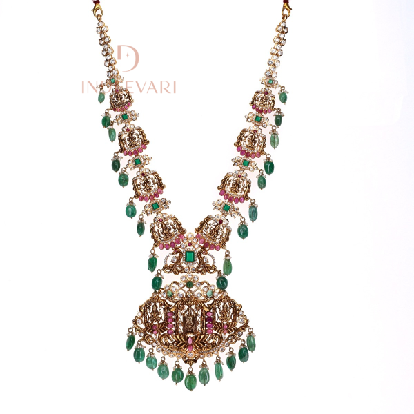 Chitra Lakshmi Pachiwork necklace in 22K gold with Goddess Lakshmi pendant, embellished with emeralds, rubies, emerald beads, CZ stones, and pearls — traditional Indian temple jewellery design